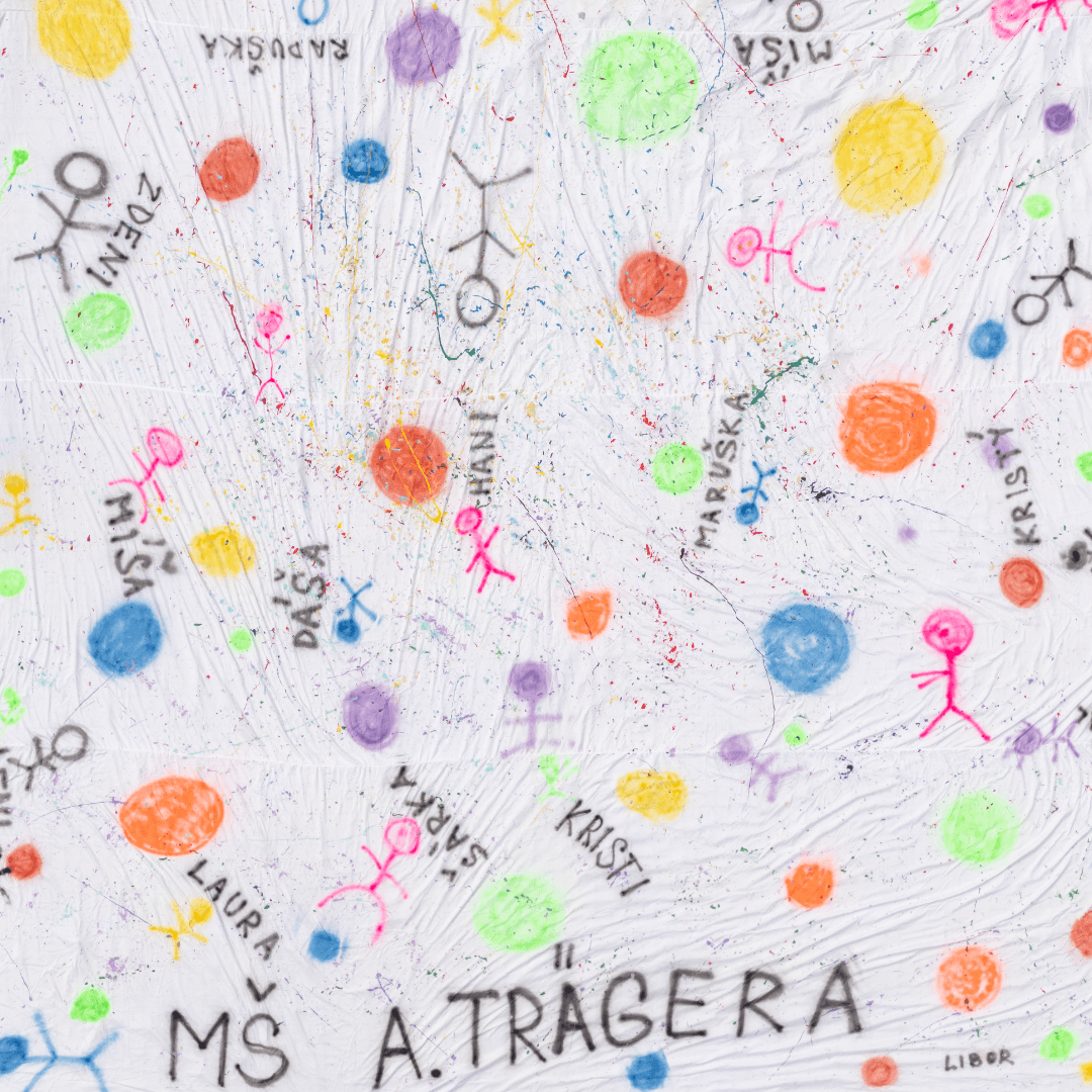 Plátno je hravé, působí vesele. Dominují mu barevné kruhy různých velikostí působící jako planety, bubliny nebo hravé tečky. Jsou rozeseté po celé ploše a vytvářejí dynamickou, rozptýlenou kompozici. Mezi nimi jsou jednoduché schematické postavičky (panáčci), nakreslené v různých barvách, často s úsměvy a ve veselých pozicích. U každé postavičky je napsané kapitálkami jméno dítěte nebo pedagoga – např. Hani, Kristý, Zdeni, Laura, Míša, Raduška, Maruška, Marťa, Libor, Dáša, Leni a další. V dolní části je nápis: MŠ A. TRÄGERA. Tvůrci použili techniku barevných sprejů a cákanců, nápisy jsou vyvedené jednoduchým fontem a černou barvou.