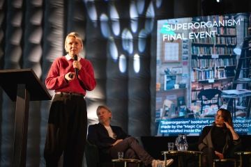 Žena prezentuje na pódiu mezinárodní projekt Magic Carpets během konference Permakulturní forum.